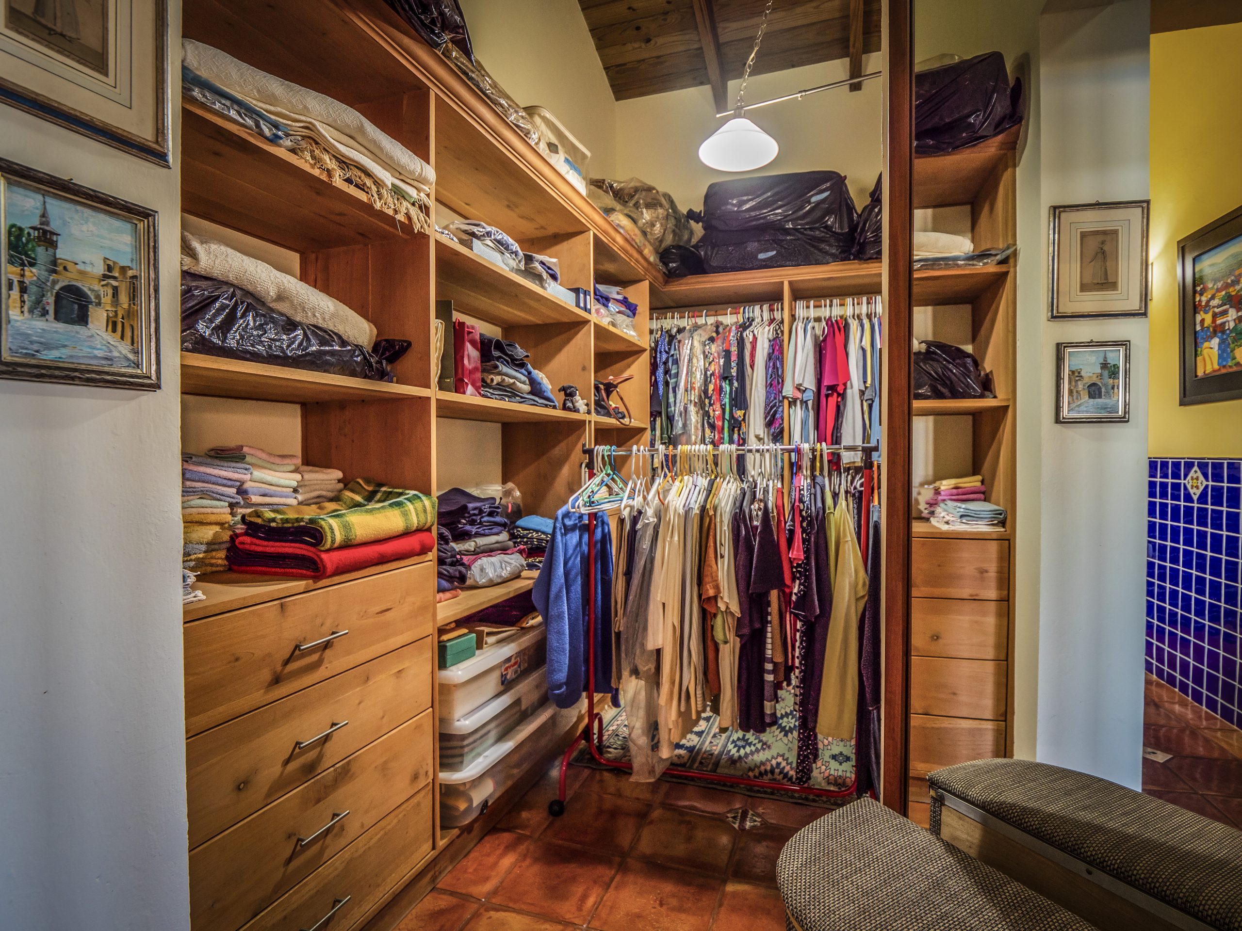 buyDRproperty Organized walk-in closet with clothes on hangers and folded linens Sosua Real Estate