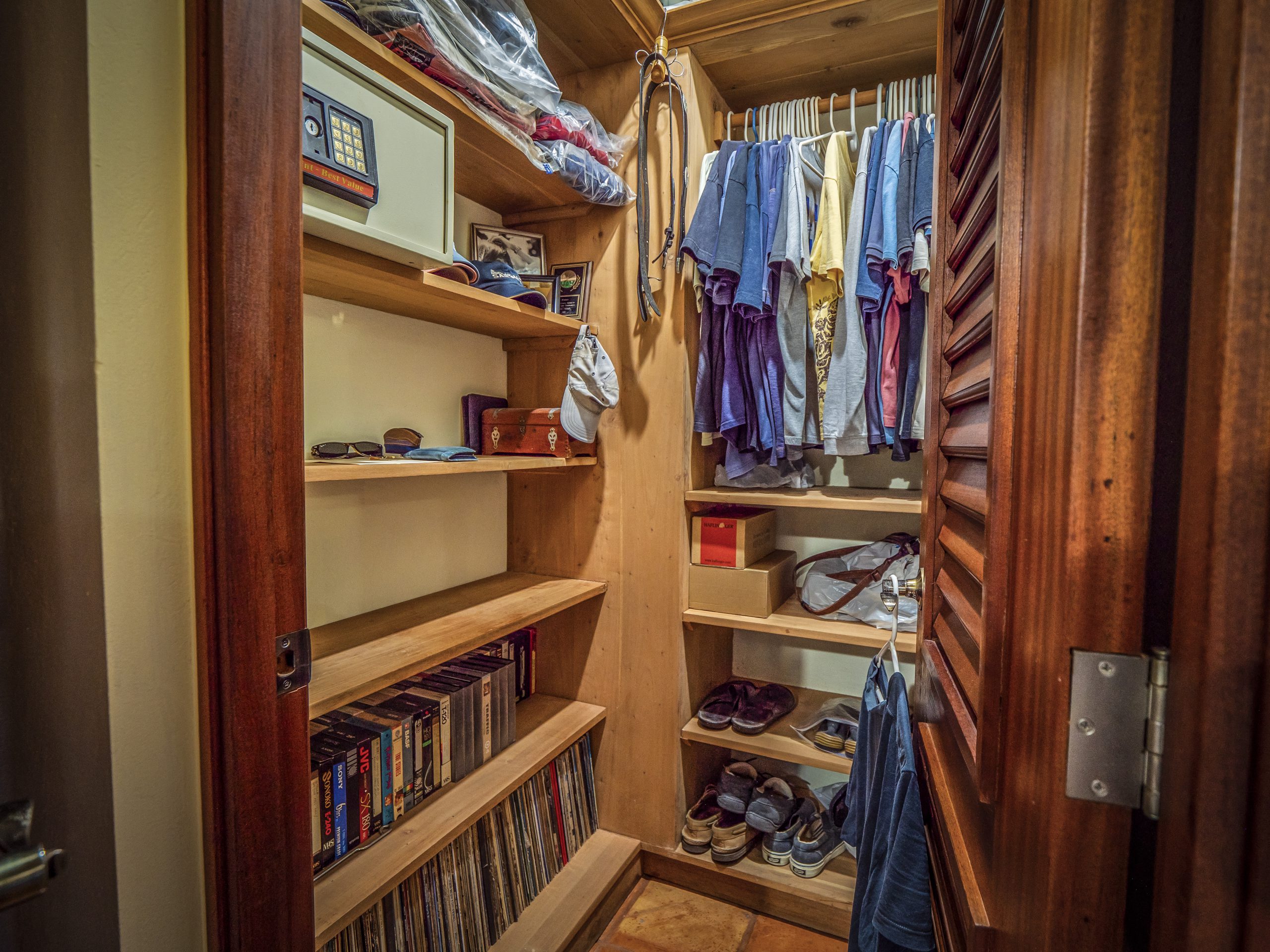 buyDRproperty Organized wooden closet with clothes, books, and folded towels Sosua Real Estate