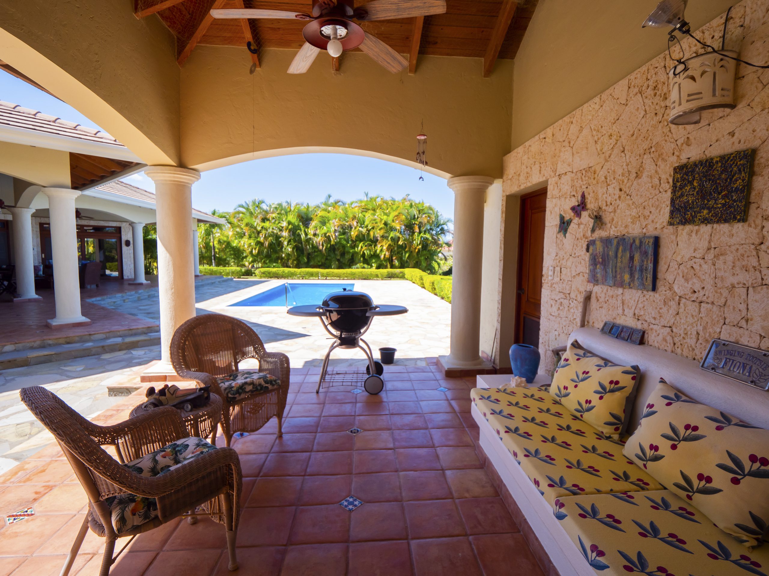 buyDRproperty Covered patio with wicker chairs, a grill, and pool view Sosua Real Estate