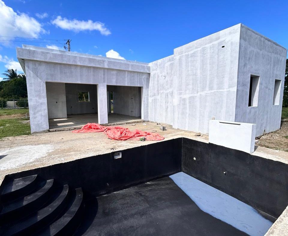 buyDRproperty Unfinished modern house with a black-bottom pool under a blue sky. Sosua Real Estate