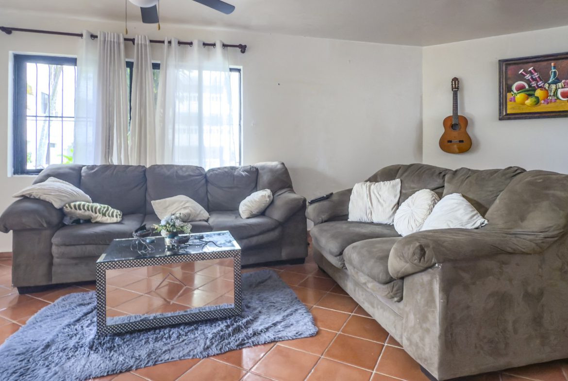 buyDRproperty Cozy living room with gray sofas, guitar on wall, and tiled floors. Great value in Sosúa. Sosua Real Estate