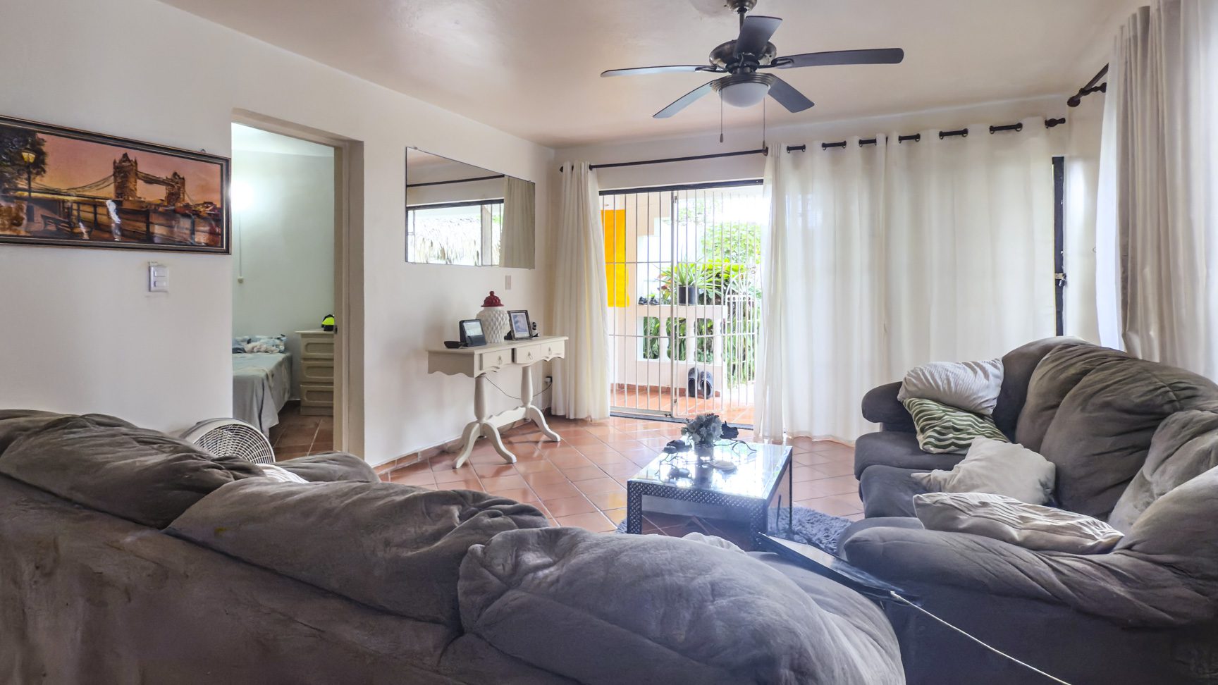 buyDRproperty Living room in Sosúa condo for sale, leading to playa balcony. Sosua Real Estate