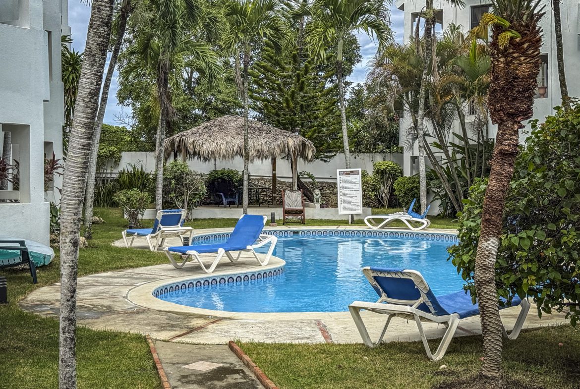 buyDRproperty Poolside at Sosúa condo with lounge chairs. Great value playa condo for sale! Sosua Real Estate