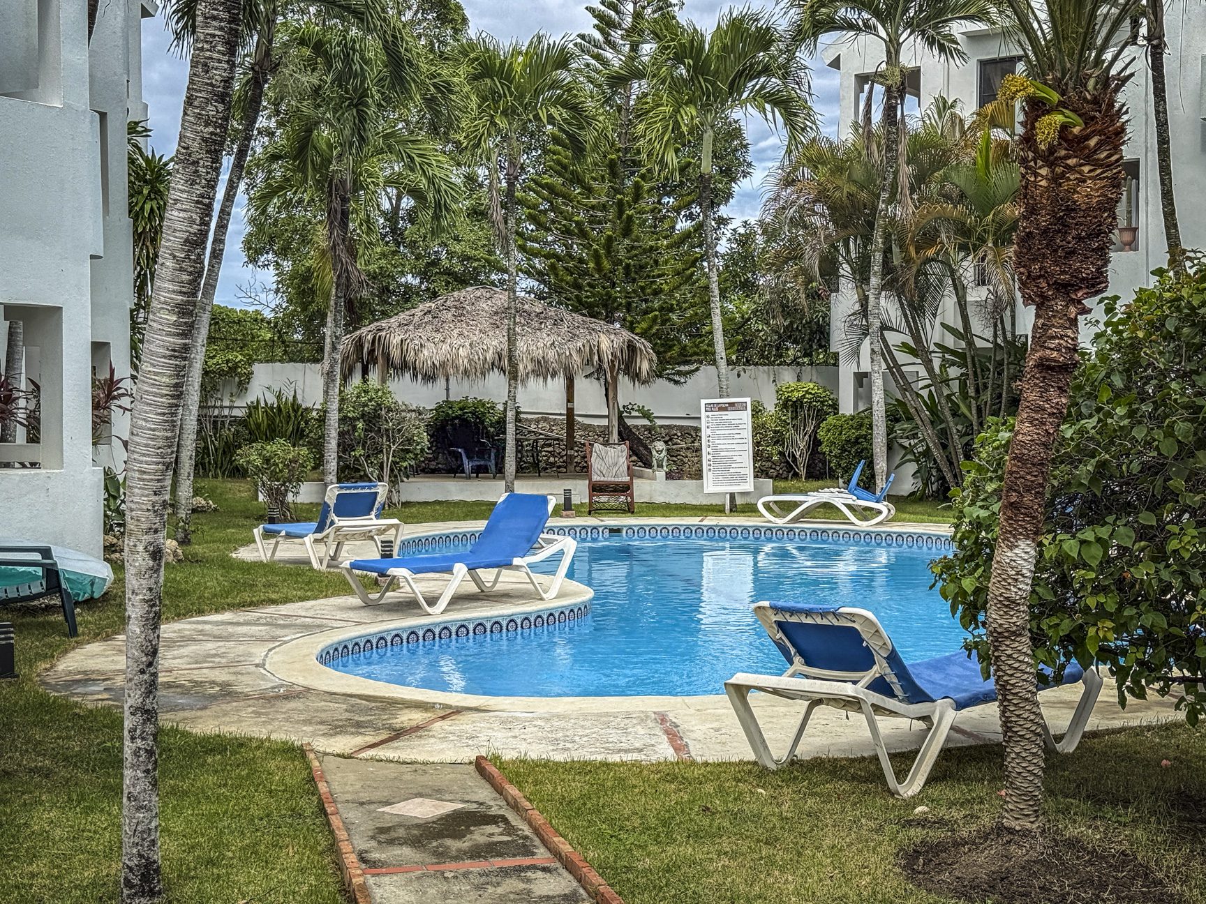 buyDRproperty Poolside at Sosúa condo with lounge chairs. Great value playa condo for sale! Sosua Real Estate