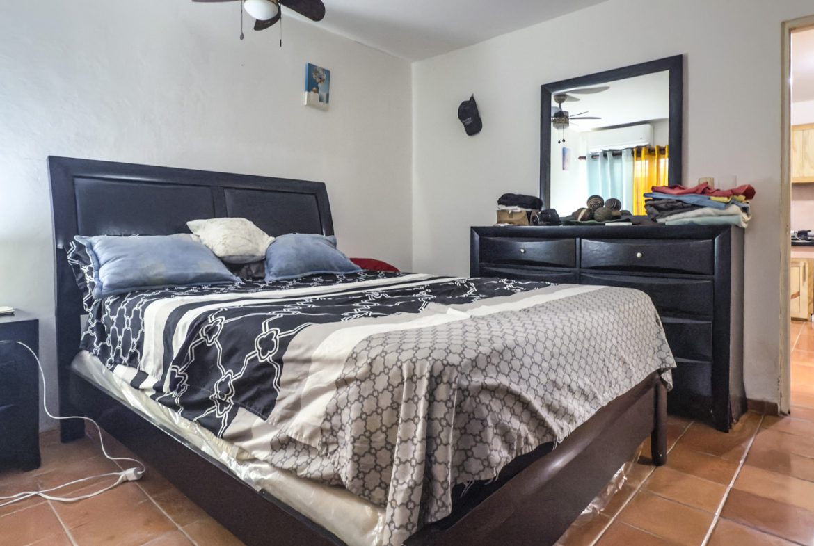 buyDRproperty Bedroom with bed, dresser, and view into kitchen. Great value Sosúa property. Sosua Real Estate