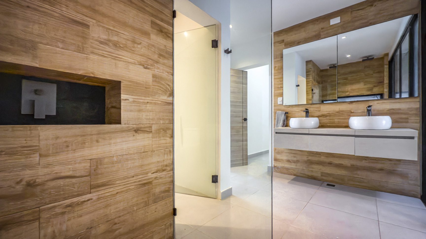 buyDRproperty Luxury bathroom in Sosua Ocean Village villa with wood paneling and double sinks. Sosua Real Estate