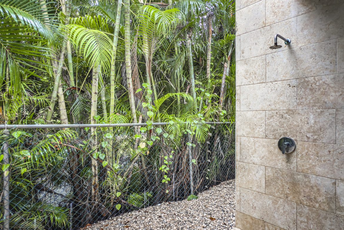 buyDRproperty Outdoor shower surrounded by lush tropical vegetation, part of a luxury villa. Sosua Real Estate