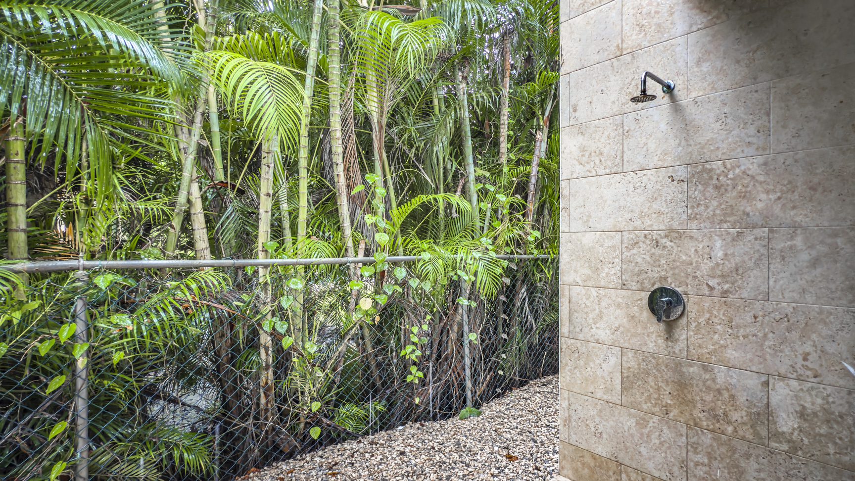 buyDRproperty Outdoor shower surrounded by lush tropical vegetation, part of a luxury villa. Sosua Real Estate