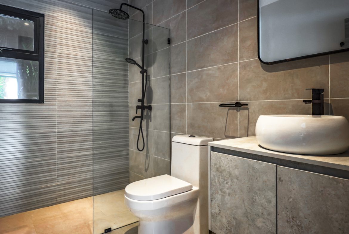 buyDRproperty Modern bathroom with shower, toilet, and sink in a luxury villa. Sosua Real Estate