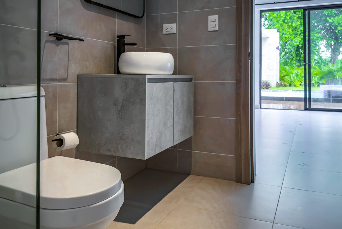 buyDRproperty Modern bathroom in a luxury villa with toilet, sink, and view to the garden. Sosua Real Estate