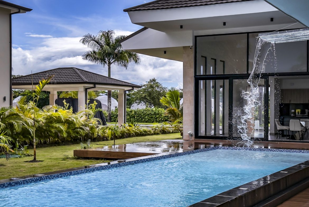 buyDRproperty Luxury villa pool in Sosua Ocean Village with waterfall feature and modern architecture. Sosua Real Estate