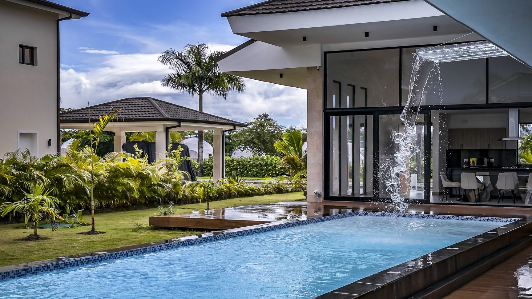 buyDRproperty Luxury villa pool in Sosua Ocean Village with waterfall feature and modern architecture. Sosua Real Estate