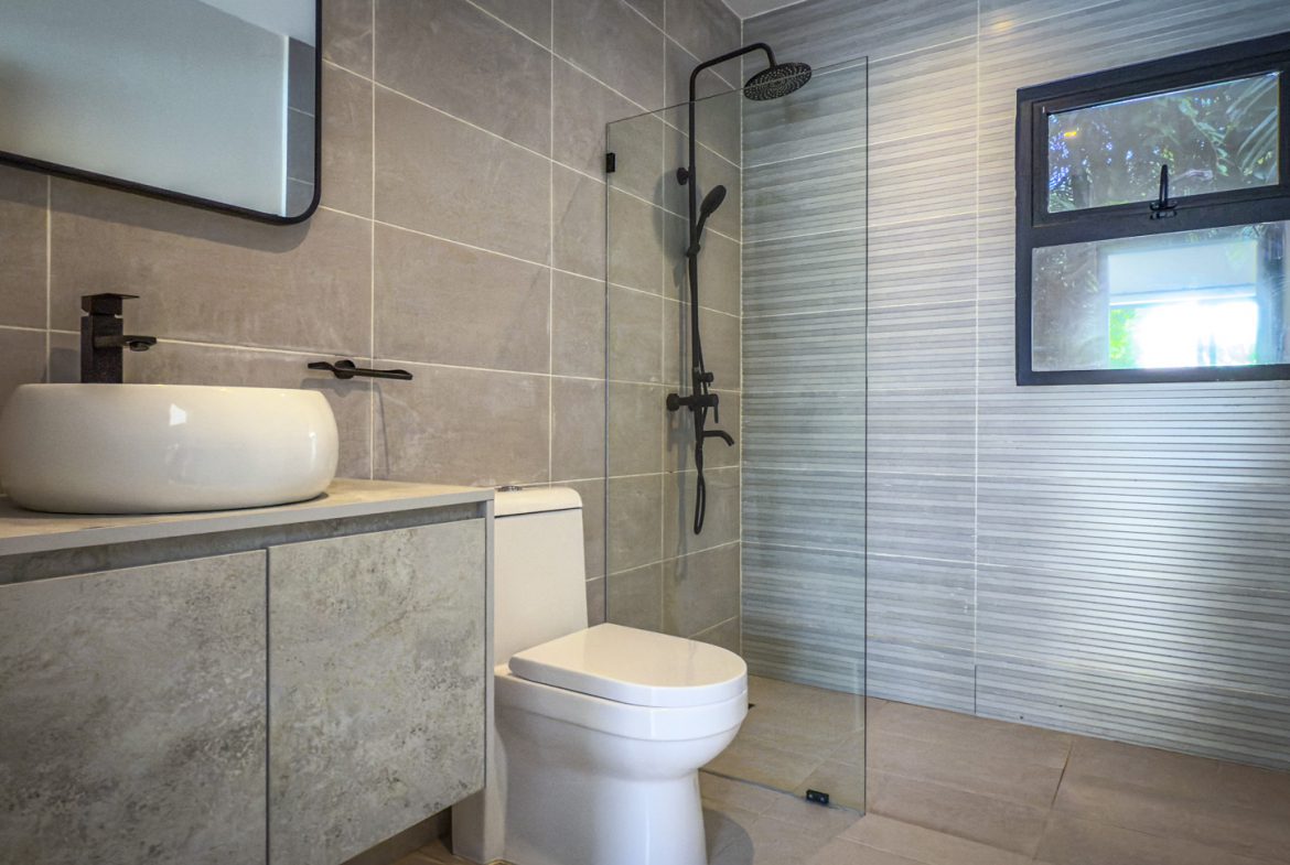 buyDRproperty Modern bathroom with walk-in shower, toilet, and sink in a luxury villa. Sosua Real Estate