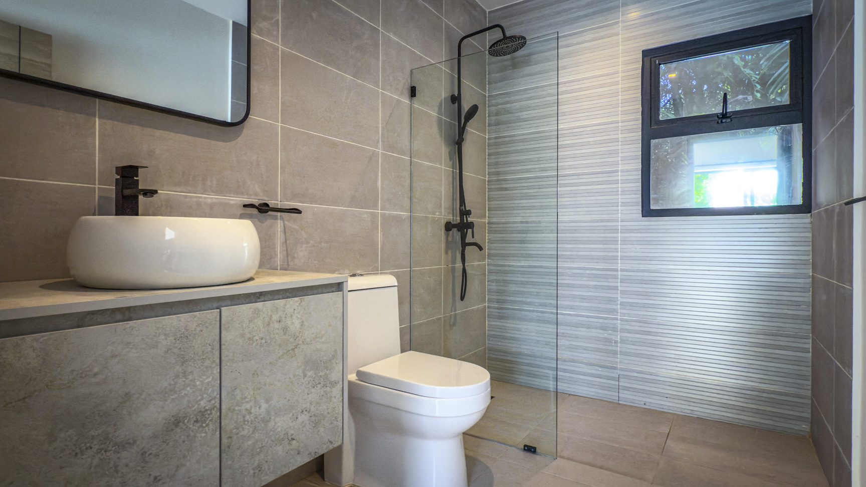 buyDRproperty Modern bathroom with walk-in shower, toilet, and sink in a luxury villa. Sosua Real Estate