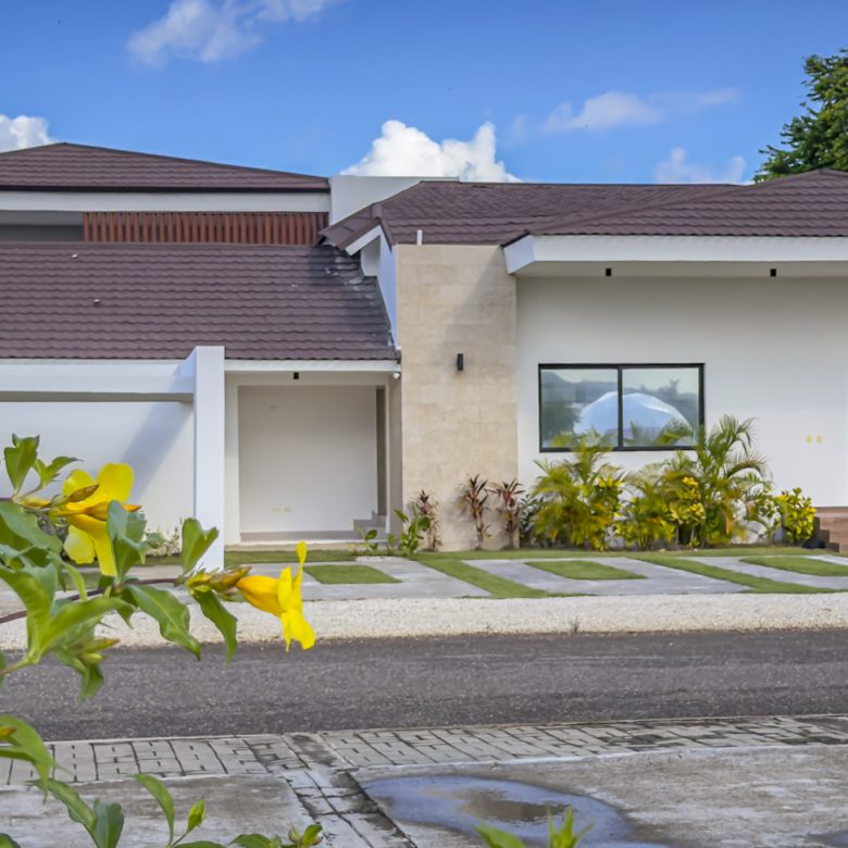 Buydrproperty Modern Luxury Villa with a Brown Roof and White Exterior Palm Trees and Blue Sky Sosua Real Estate Buydrpropertycom Buydrpropertycom