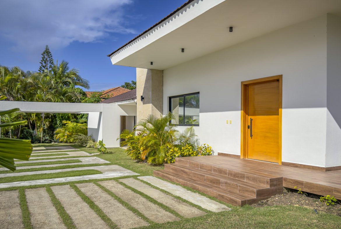buyDRproperty Modern luxury villa entrance with wooden door and walkway in Sosua Ocean Village. Sosua Real Estate