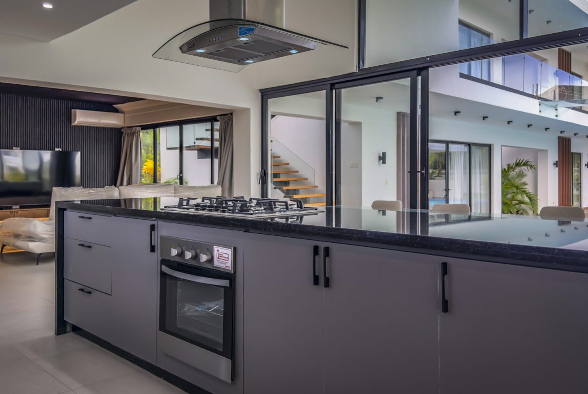 buyDRproperty Luxury villa kitchen with black countertops and stainless steel appliances in Sosua Ocean Village. Sosua Real Estate