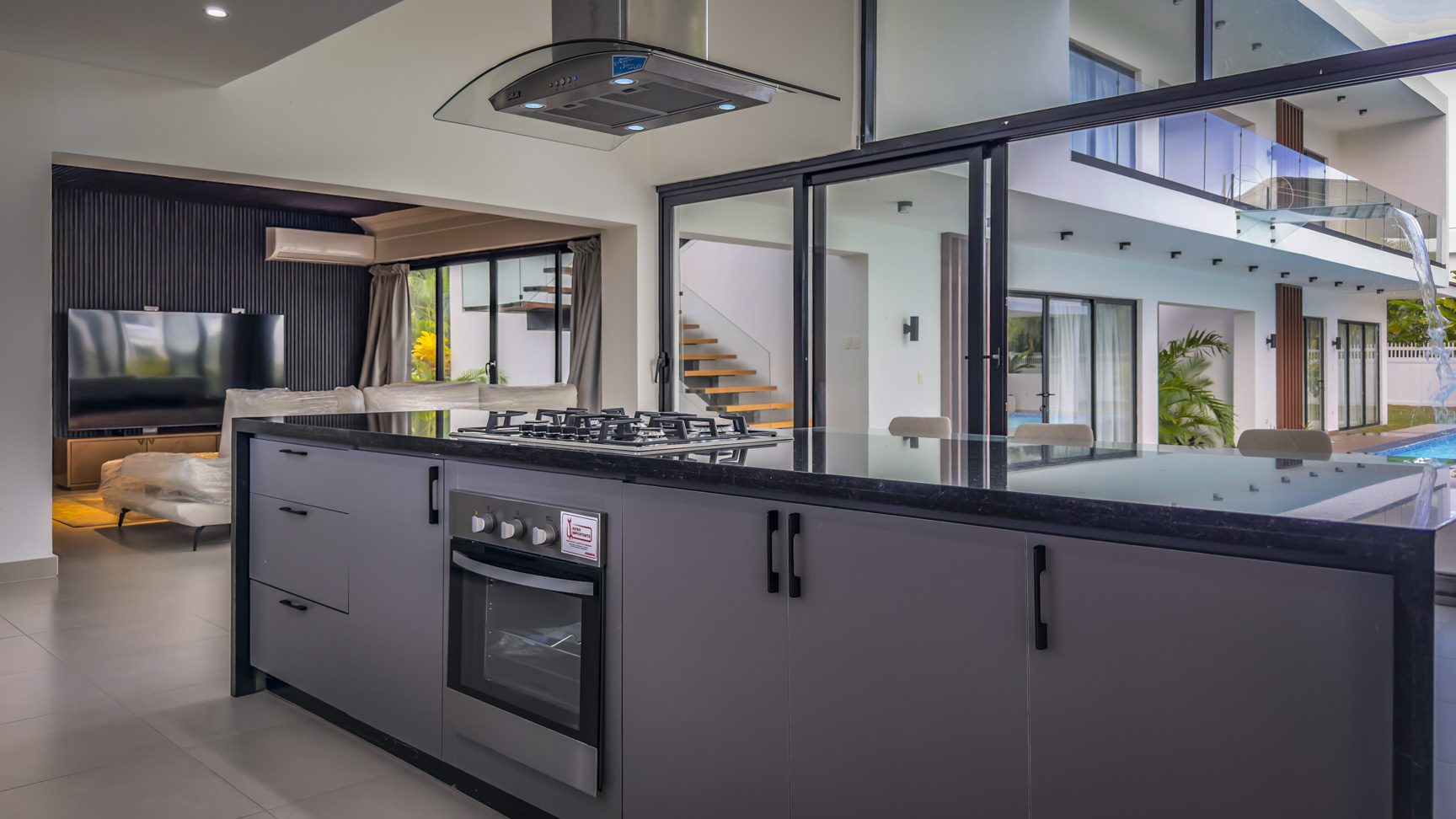 buyDRproperty Luxury villa kitchen with black countertops and stainless steel appliances in Sosua Ocean Village. Sosua Real Estate