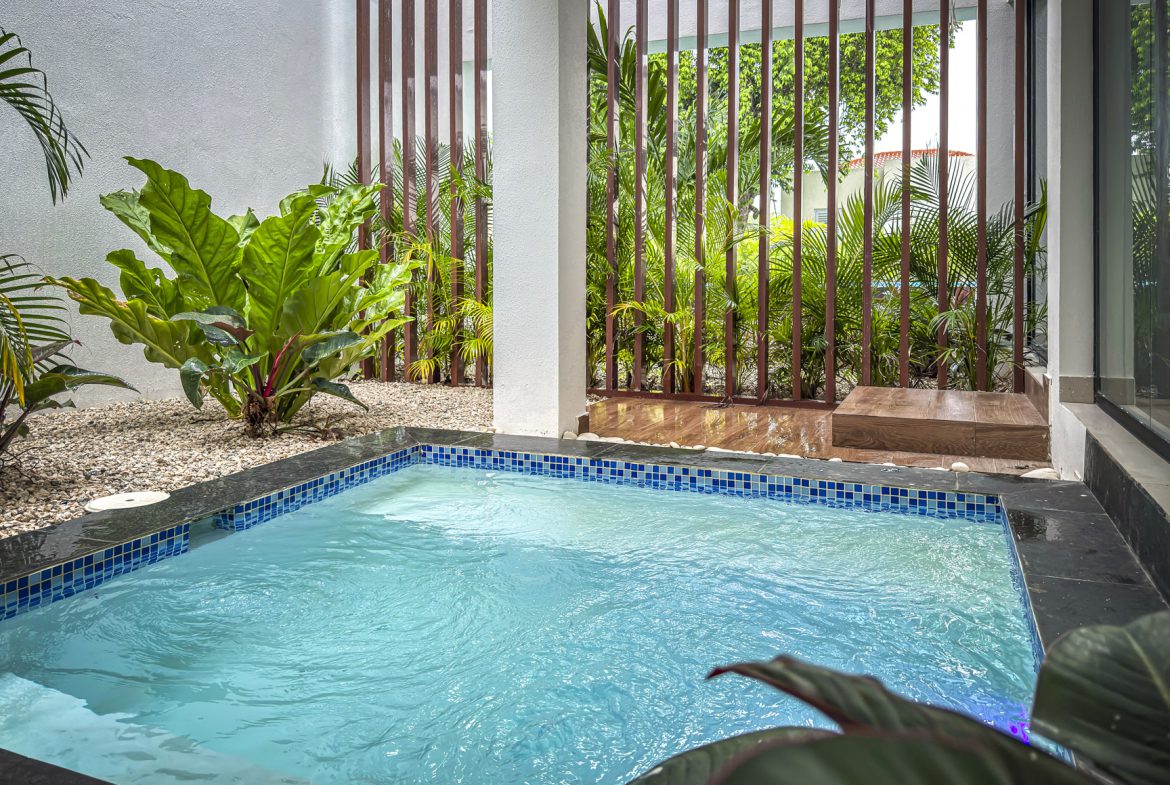 buyDRproperty Luxury villa's private plunge pool in Sosua Ocean Village, surrounded by lush greenery and modern design. Sosua Real Estate
