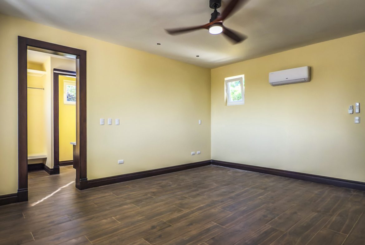 buyDRproperty Bedroom interior of 3 bedroom villa for sale in La Mulata, with hardwood floors and dark wood trim. Sosua Real Estate