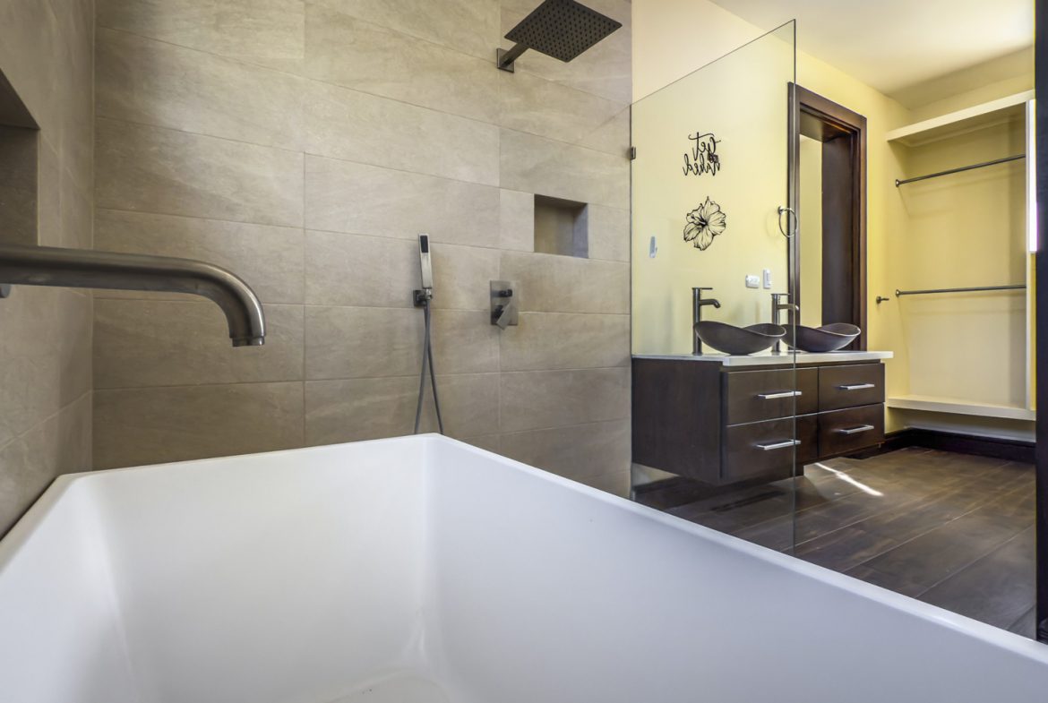 buyDRproperty Modern bathroom with tub, shower, double vanity, and walk-in closet in La Mulata villa. Sosua Real Estate