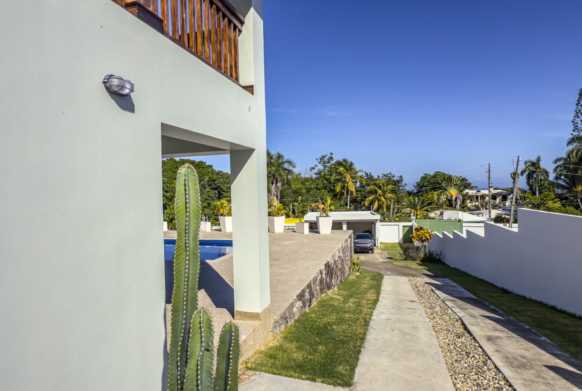 buyDRproperty Exterior view of the 3-bedroom villa in La Mulata, featuring a pool, driveway, and modern architecture. Sosua Real Estate