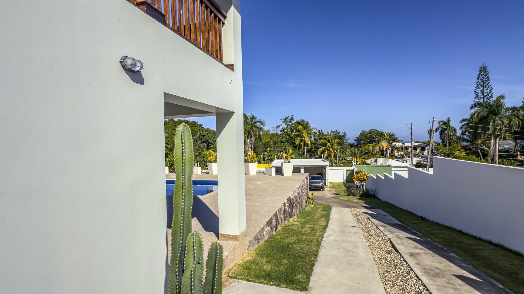 buyDRproperty Exterior view of the 3-bedroom villa in La Mulata, featuring a pool, driveway, and modern architecture. Sosua Real Estate