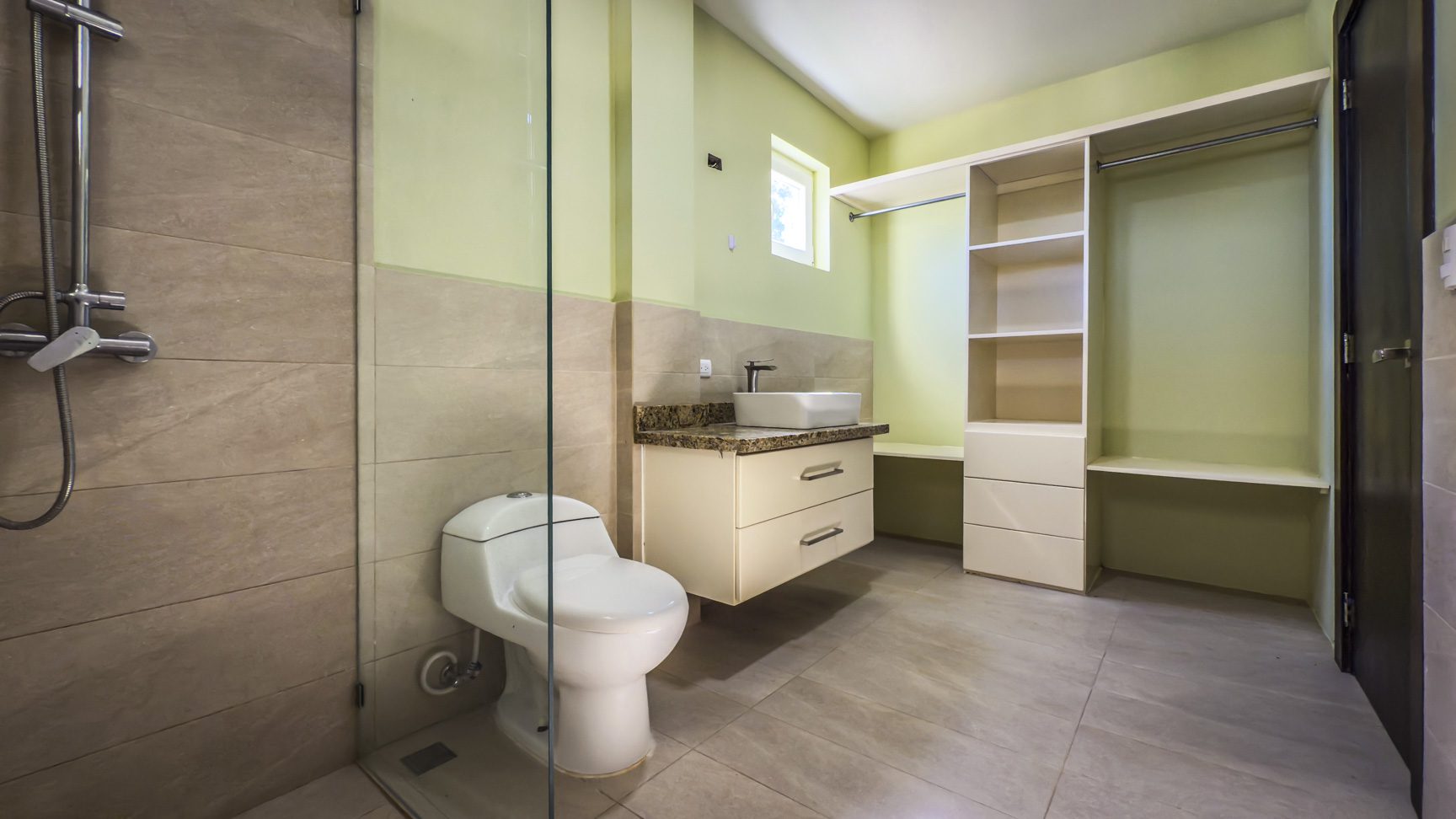 buyDRproperty Bathroom with toilet, shower, vanity, and open wardrobe in La Mulata villa. Sosua Real Estate