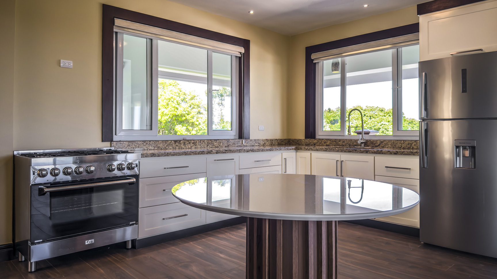 buyDRproperty Modern kitchen with stainless steel appliances and large windows in La Mulata villa. Sosua Real Estate