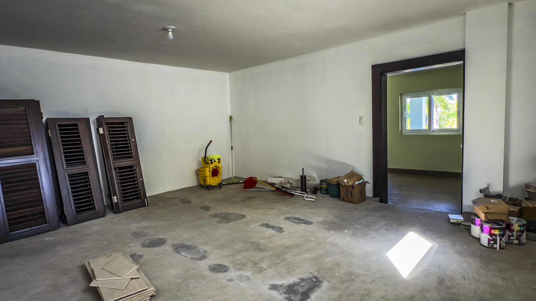 buyDRproperty Unfinished room in La Mulata villa for sale, showing concrete floor, shutters, and doorway. Sosua Real Estate