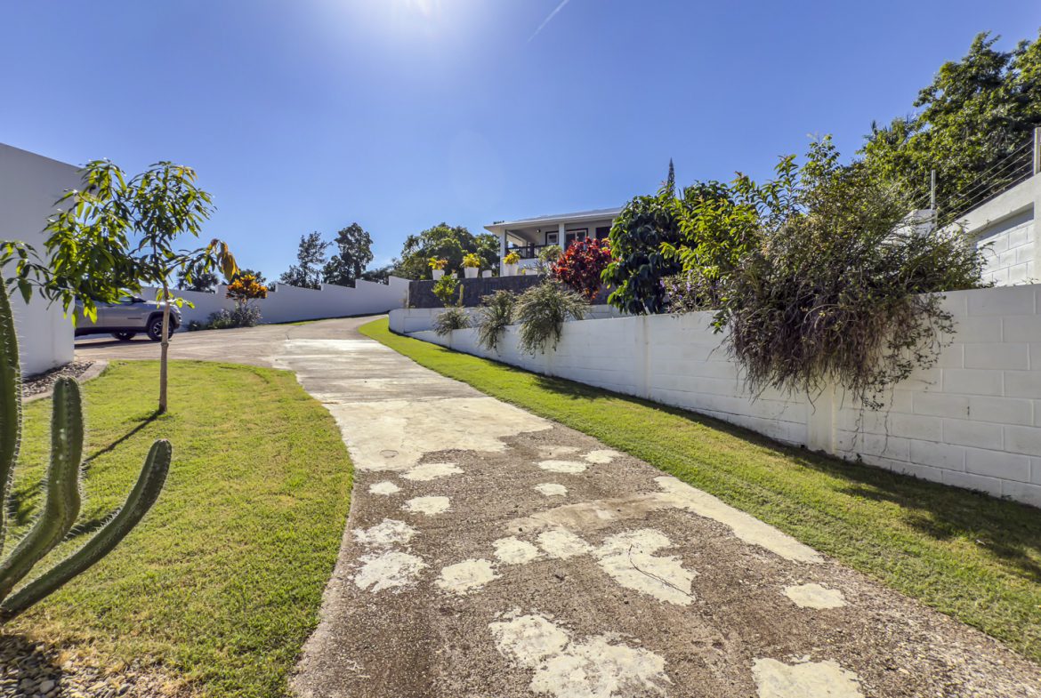 buyDRproperty Driveway leading to a 3 bedroom villa in La Mulata, Dominican Republic, showcasing the property's entrance. Sosua Real Estate