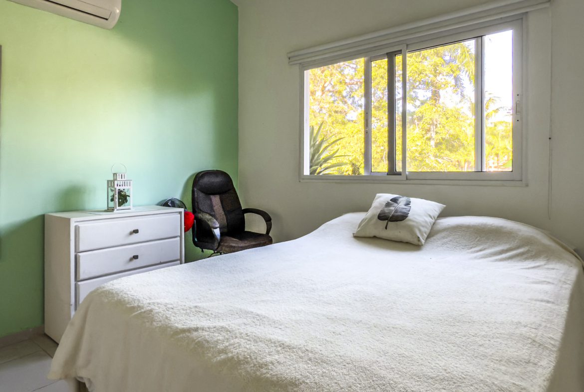 buyDRproperty Bright bedroom in a Colibri villa with a window, bed, and dresser. Sosua Real Estate