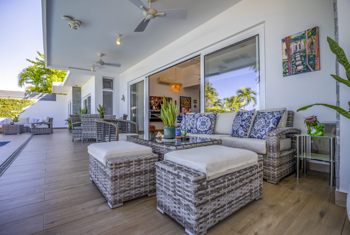 buyDRproperty Outdoor patio with wicker furniture, cushions, and sliding glass doors. Sosua Real Estate