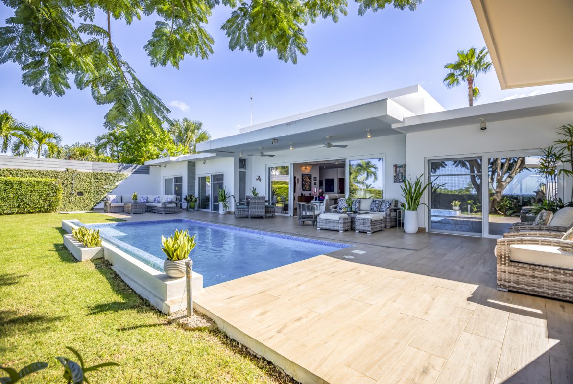 buyDRproperty Luxury villa with pool, patio, and lush green lawn. Sosua Real Estate