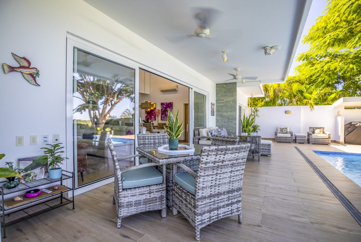 buyDRproperty Outdoor patio with wicker furniture, pool, and sliding glass doors. Sosua Real Estate