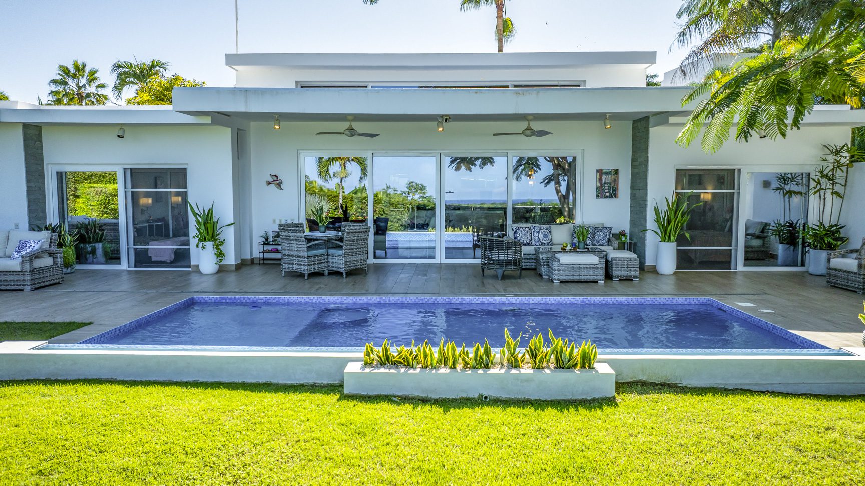 buyDRproperty Luxury villa with pool, patio furniture, and tropical landscaping. Outdoor living at its finest. Sosua Real Estate