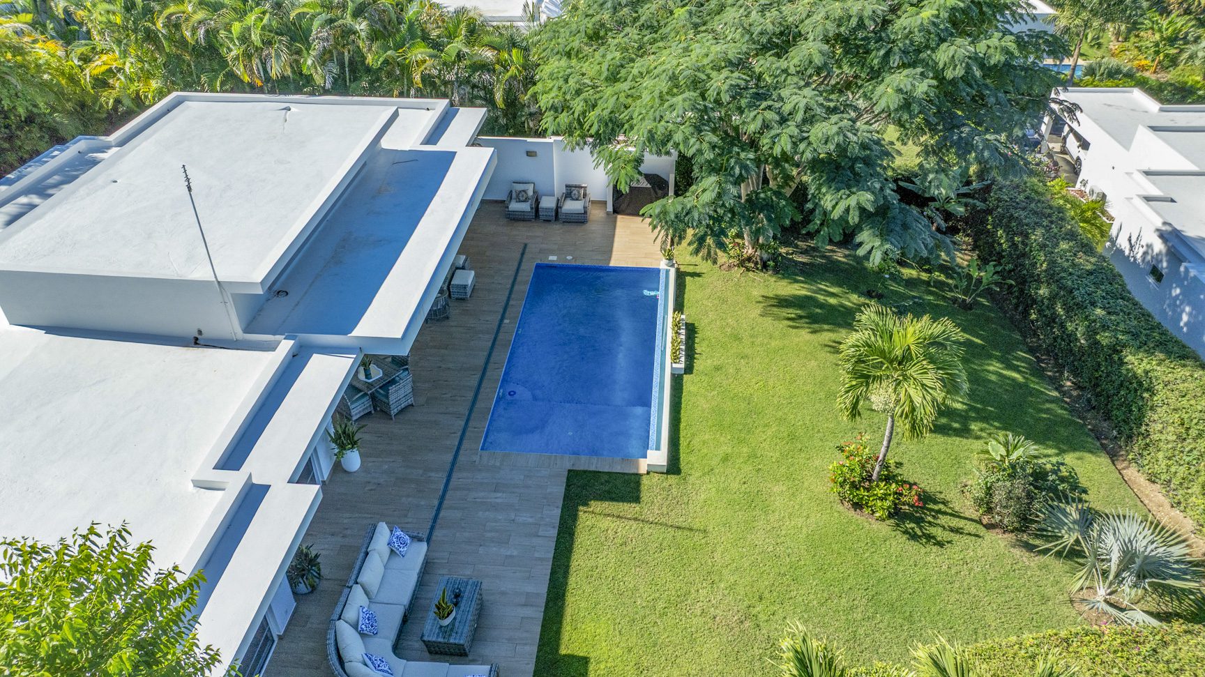 buyDRproperty Aerial view of a Caribbean villa with a luxury pool surrounded by lush greenery. Sosua Real Estate