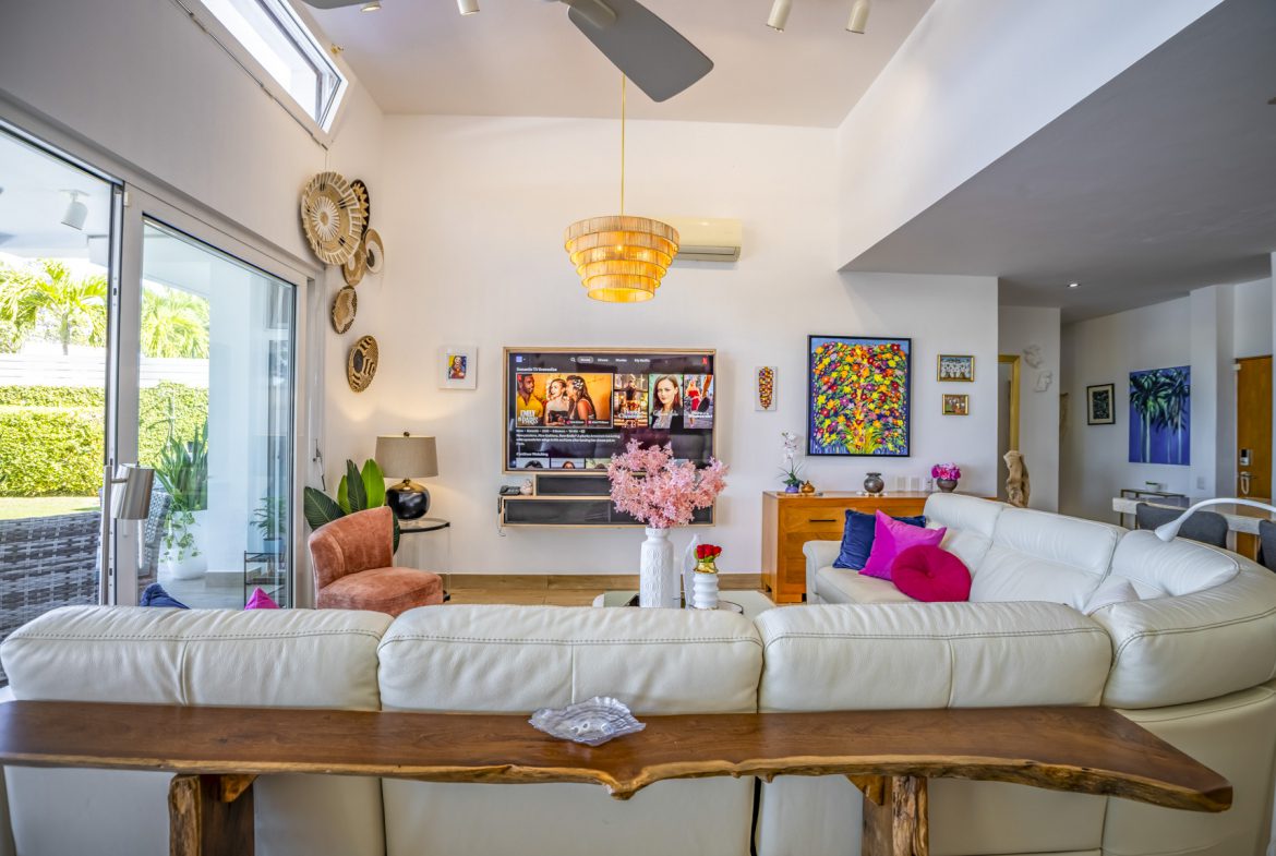 buyDRproperty Bright living room with white sofas, colorful pillows, and wall art Sosua Real Estate