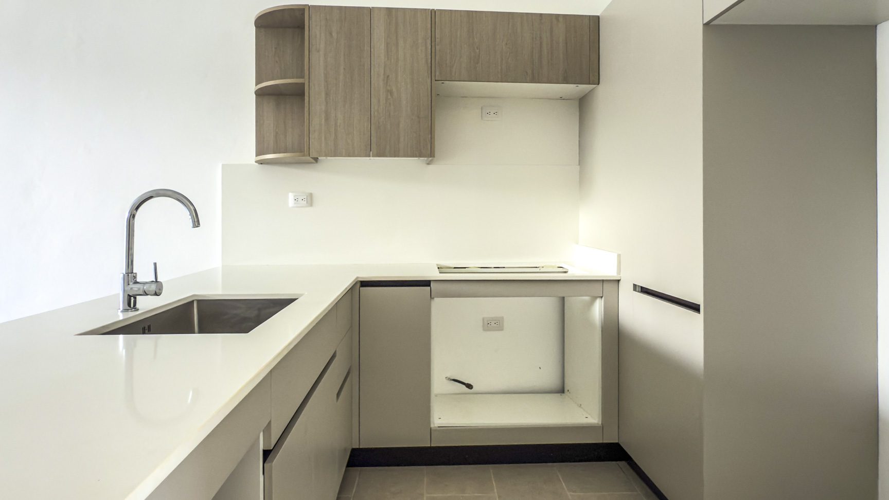 buyDRproperty Modern kitchen with stainless steel sink, light wood cabinets, and white countertops. Sosua Real Estate