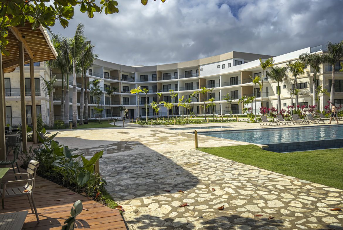 buyDRproperty Luxury resort with pool and palm trees under a cloudy sky Sosua Real Estate