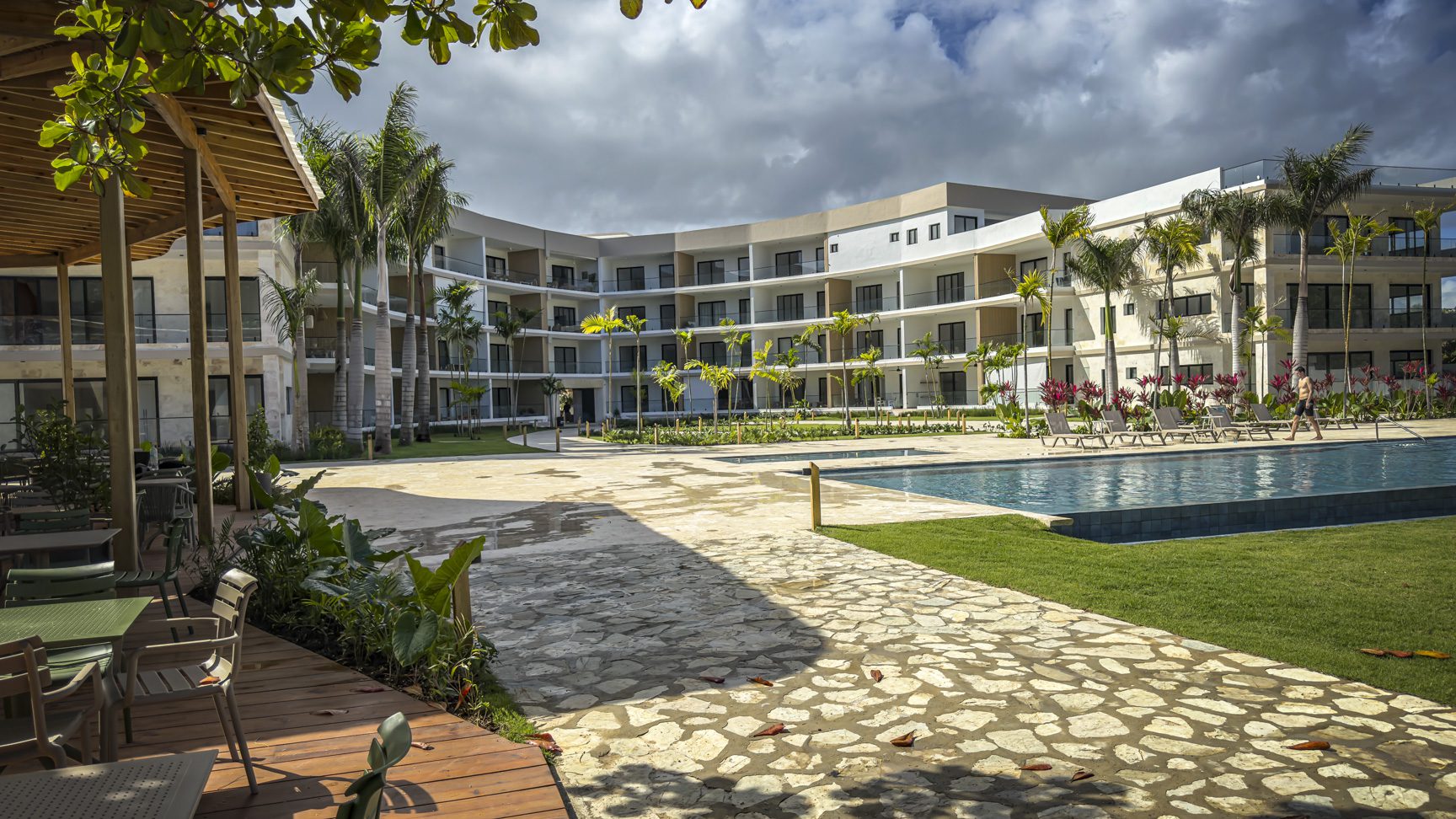 buyDRproperty Luxury resort with pool and palm trees under a cloudy sky Sosua Real Estate