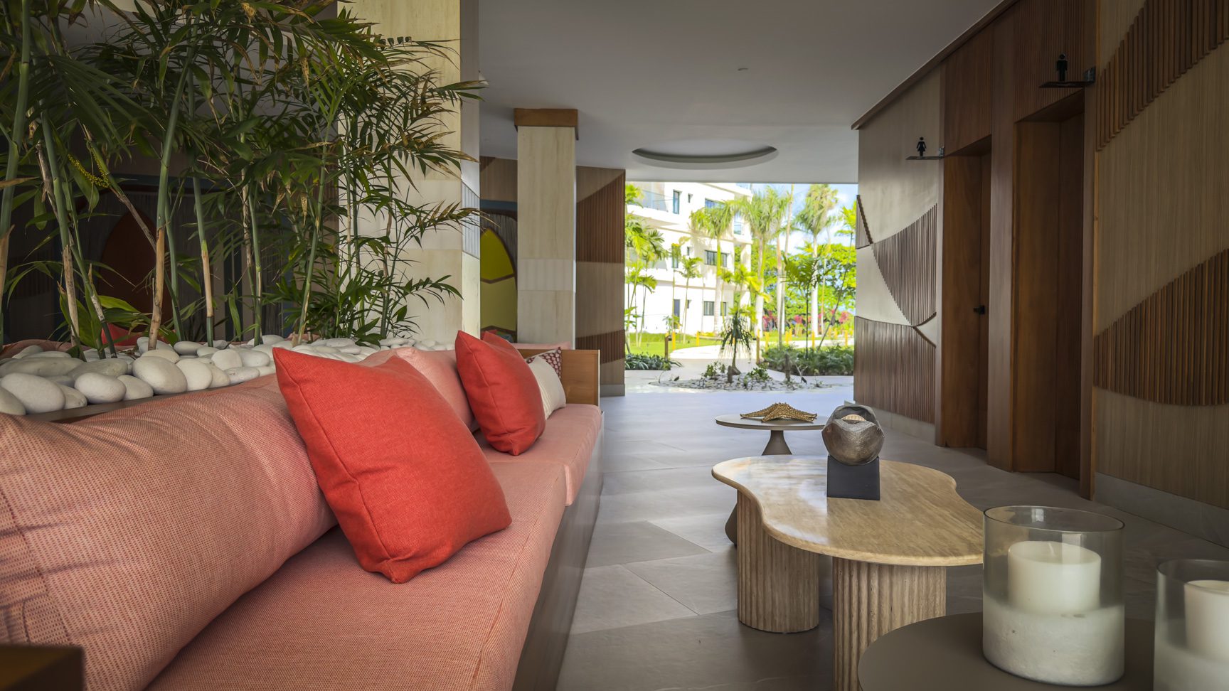 buyDRproperty Elegant hotel lobby with coral sofa, tropical plants, and view to the garden. Sosua Real Estate