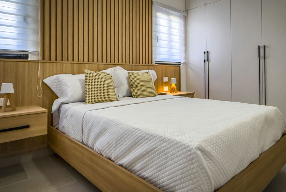 Modern bedroom in The Wave condo, Cabarete, with wooden accents.