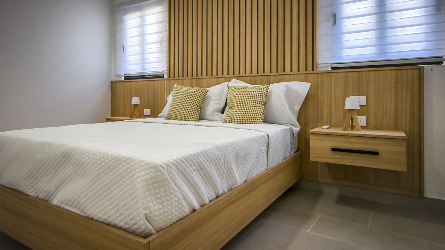 Oceanfront 2BR condo bedroom at The Wave, Cabarete, with modern wood accents.