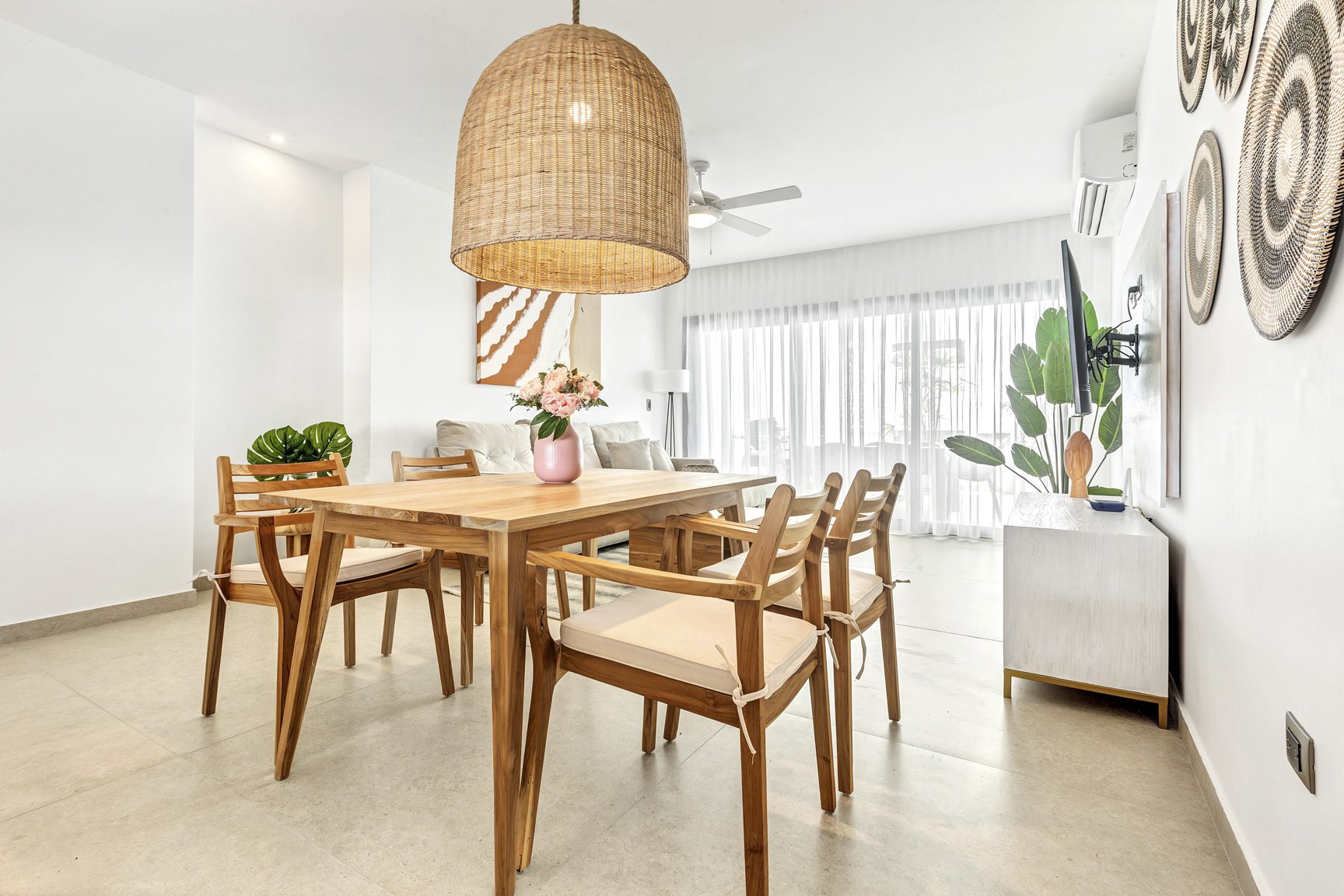 buyDRproperty Light wood dining set under a woven pendant in a modern living space. Sosua Real Estate