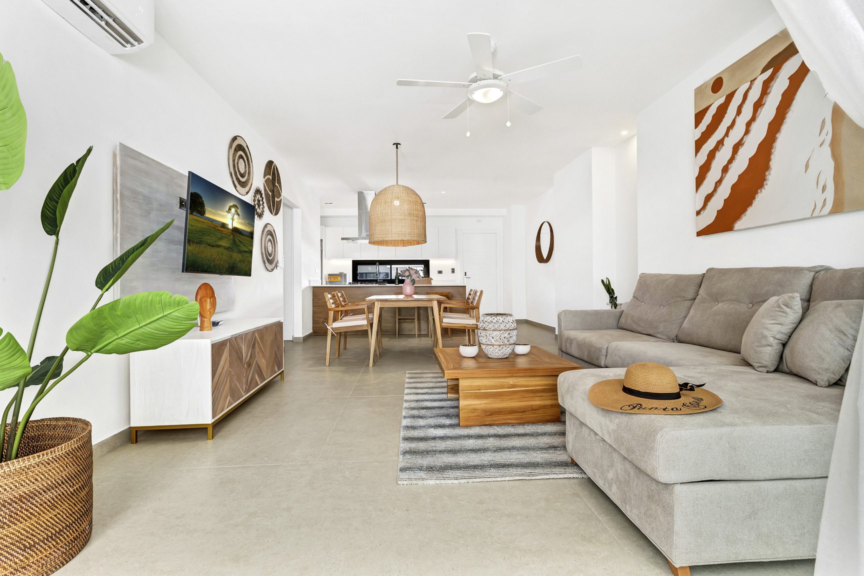 buyDRproperty Modern living room with gray couch, wooden coffee table, and potted plant Sosua Real Estate