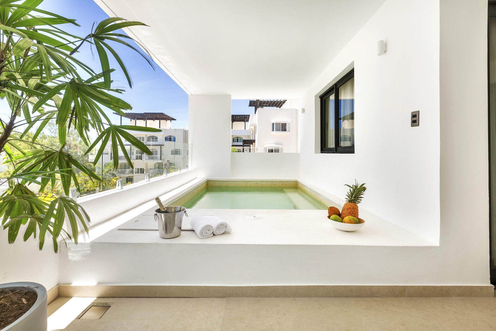 buyDRproperty Luxury resort balcony with plunge pool, fresh fruit, and chilled champagne. Tropical vacation vibes. Sosua Real Estate