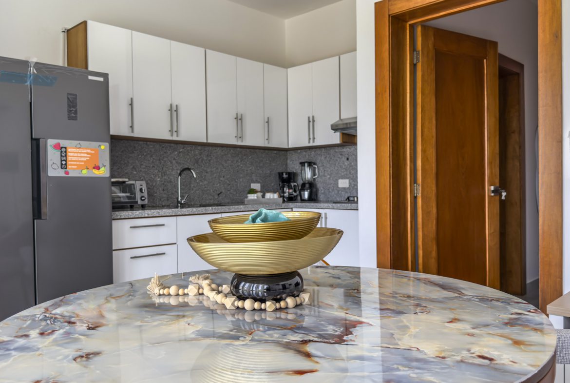 Modern kitchen with marble table and decorative bowls.