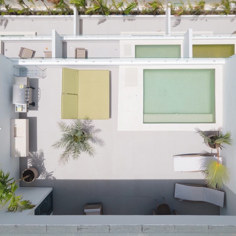 buyDRproperty Aerial view of a modern rooftop terrace with pool, lounge area, and lush greenery. Sosua Real Estate