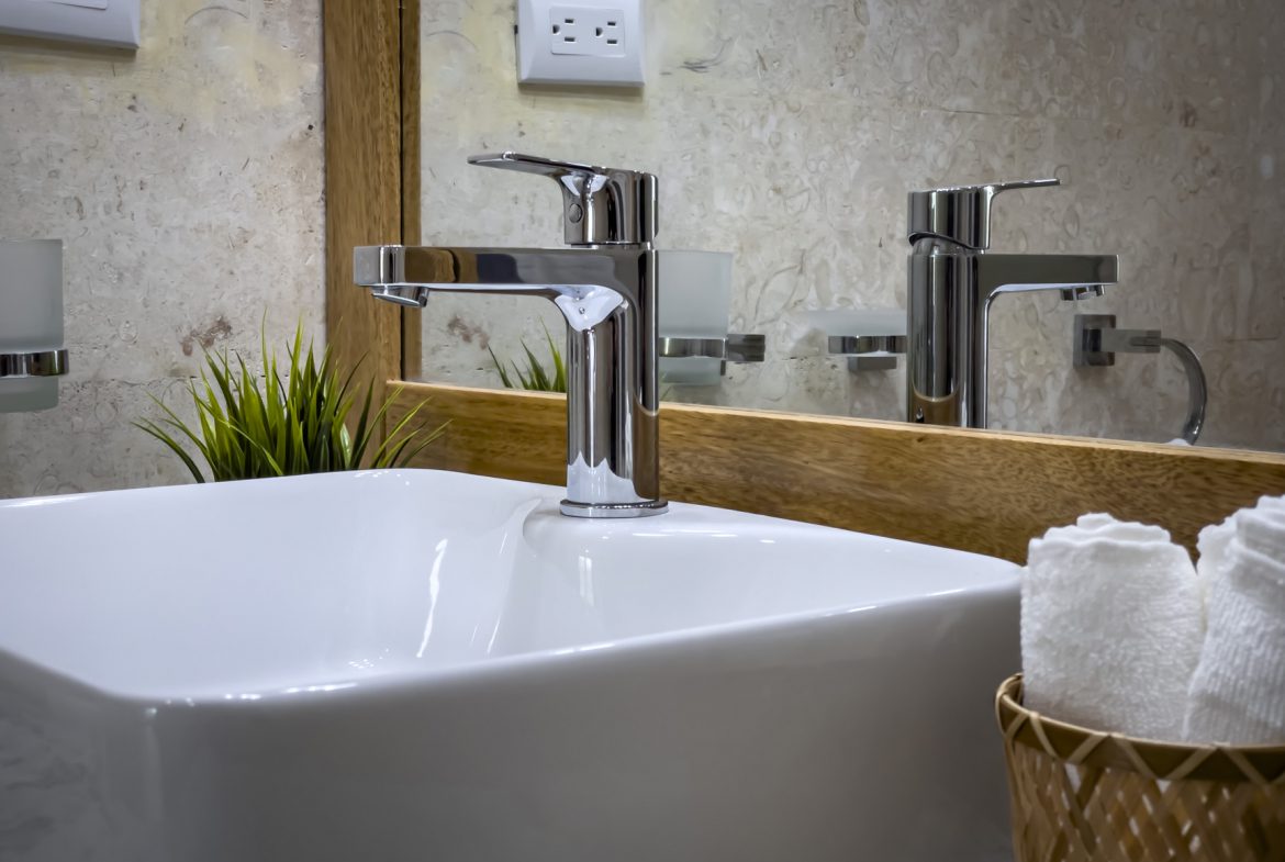 buyDRproperty Modern bathroom sink with chrome faucet, white square basin, and rolled towels. Sosua Real Estate